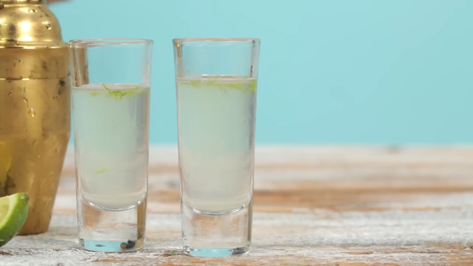 Two Freshly Made Kamikaze Shots in Clear Shot Glasses with Lime Zest on Top