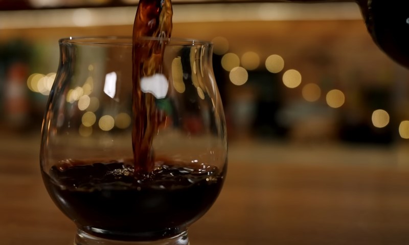 Black rum being poured into a glass