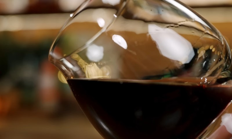 A glass of black rum slightly tilted to the left